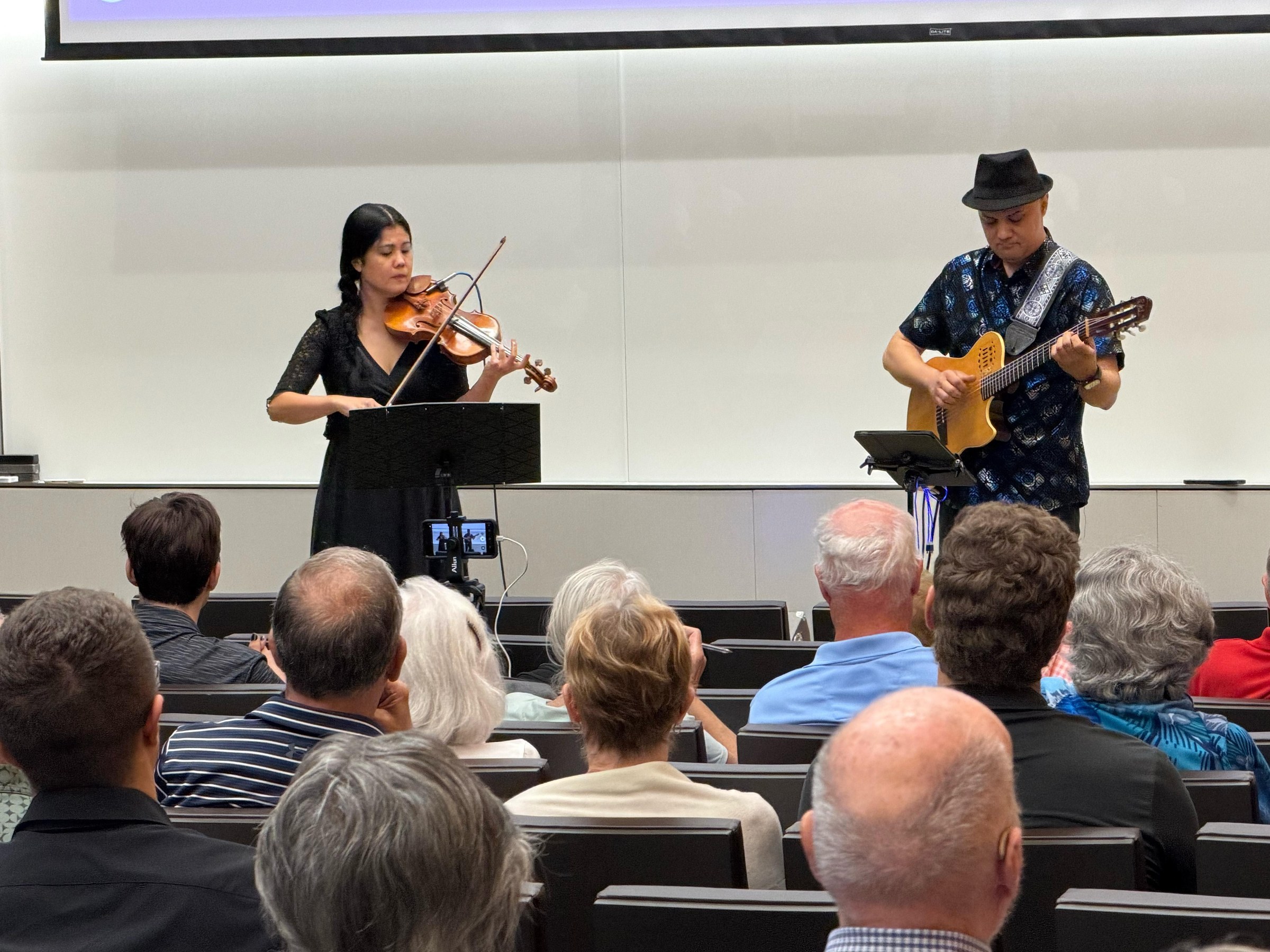 Groupe de musique live sur scène devant un public éclairé par les projecteurs